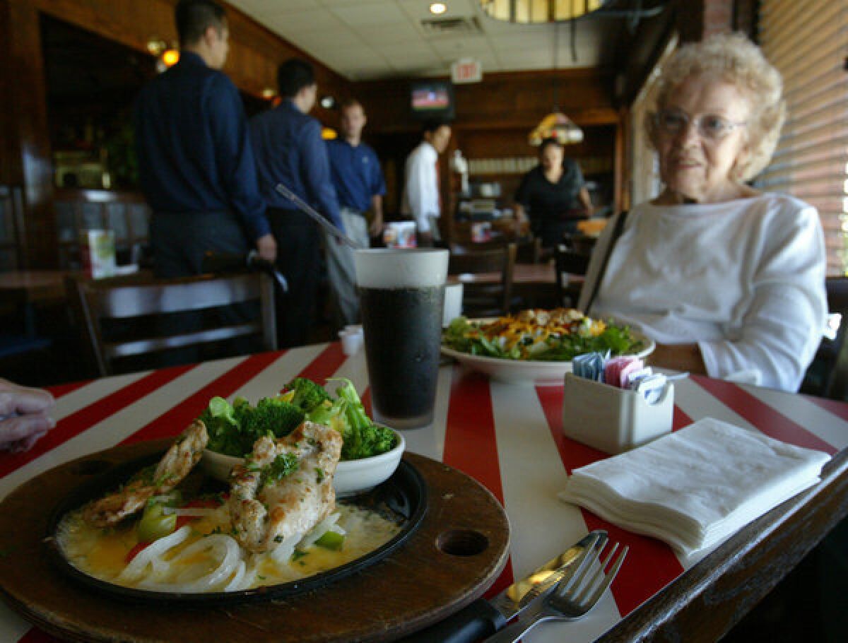Shirley Booker sits at a table at TGI Fridays in Los Angeles. The chain might be sold, its parent company Carlson said.