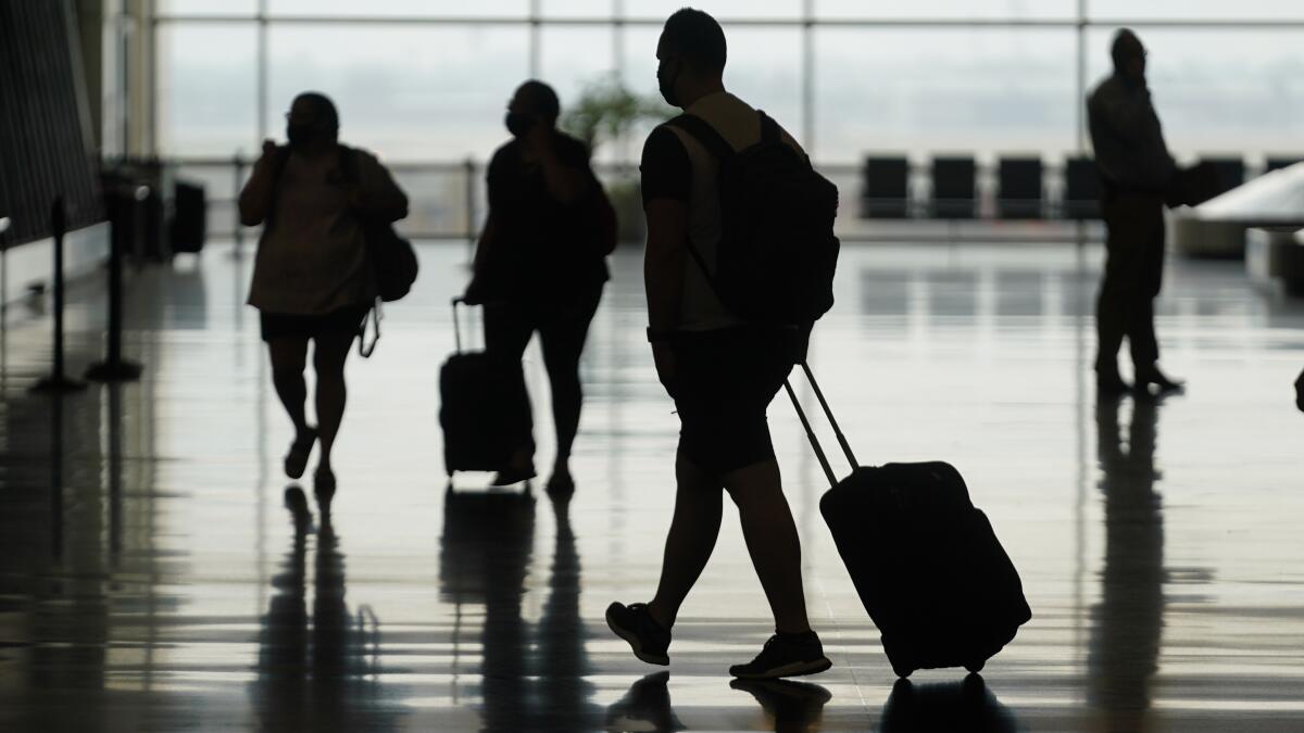 ARCHIVO - Viajeros caminan por el Aeropuerto Internacional de Salt Lake City, Utah,
