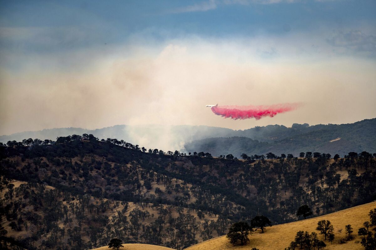 An air tanker drops retardant while battling one of several wildfires comprising the Deer Zone fires a unincorporated Contra Costa County, Calif., on Sunday, Aug. 16, 2020. Firefighters scrambled to contain multiple blazes, sparked by widespread lightning strikes throughout the region, as a statewide heat wave continues. (AP Photo/Noah Berger)