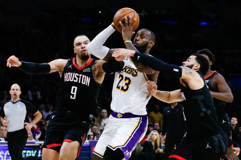 LOS ANGELES, CA - NOVEMBER 19: Los Angeles Lakers forward LeBron James (23) drives to the basket between Houston Rockets forward Dillon Brooks (9) and guard Fred VanVleet (5) during the second half at Crypto.com Arena on Sunday, Nov. 19, 2023 in Los Angeles, CA. (Allen J. Schaben / Los Angeles Times)