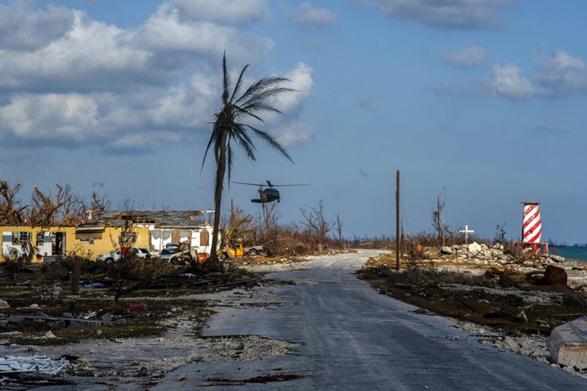 A helicopter flies over the village of High Rock after delivering emergency supplies in the aftermath of Hurricane Dorian in the Bahamas.