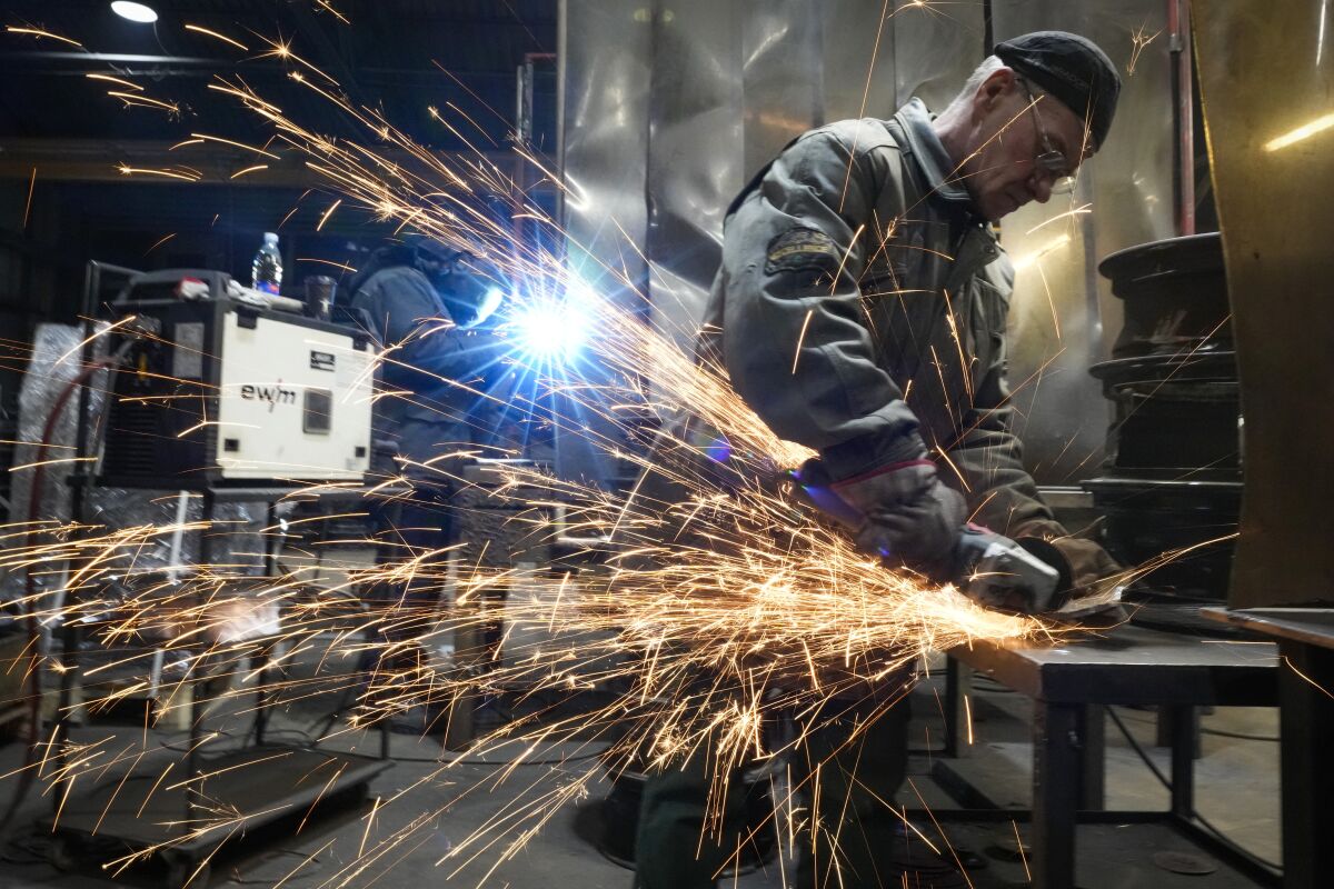 Sparks fly as a welder works at a workbench