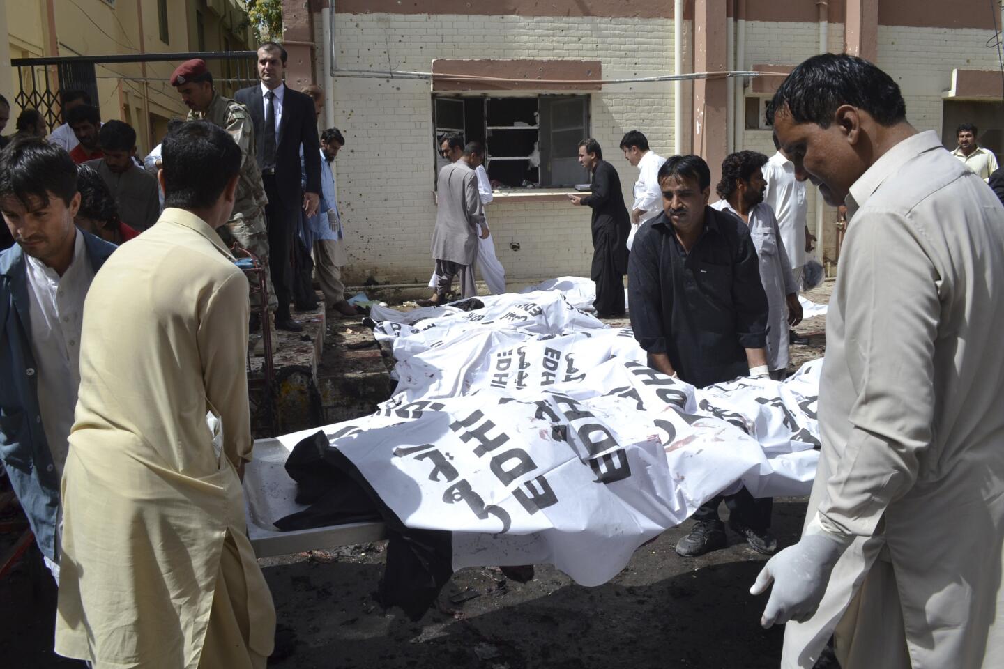 People carry dead bodies of victims in a bomb blast in Quetta, Pakistan, Monday, Aug. 8, 2016.