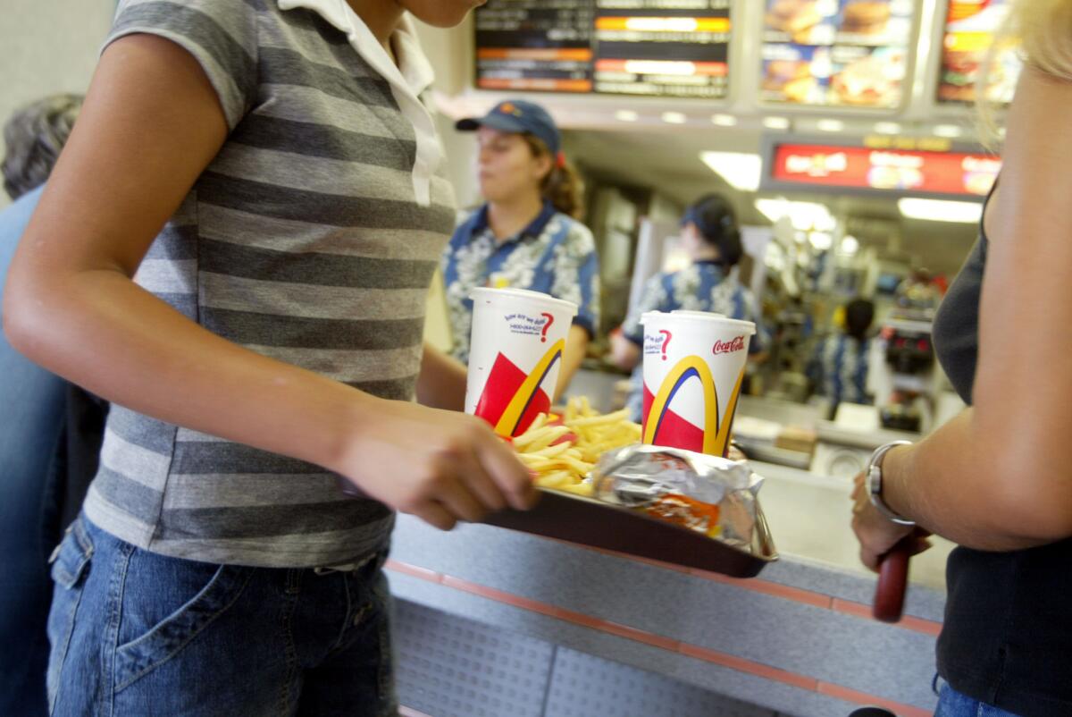 A customer carries a tray of food at McDonald's.