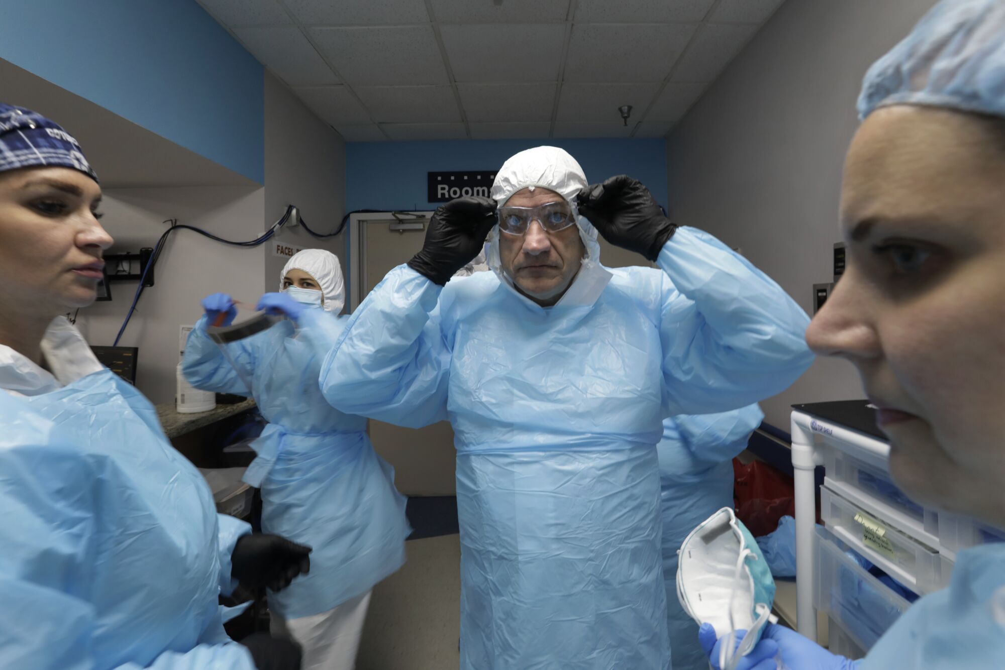 Dr. Joseph Varon, center, prepares to enter the COVID unit at United Memorial Medical Center with nurses Tanna Ingraham, left and Jerusha Harshman.