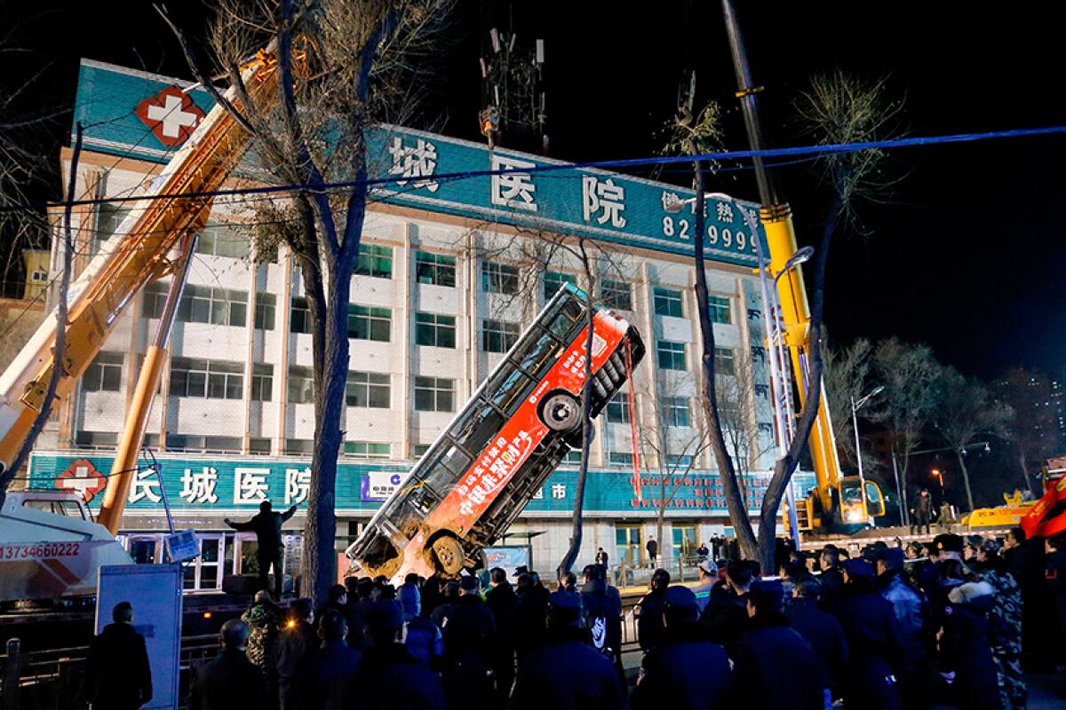 A crane is used to lift a bus out of a sinkhole Jan. 13 in the city of Xining in northwestern China.