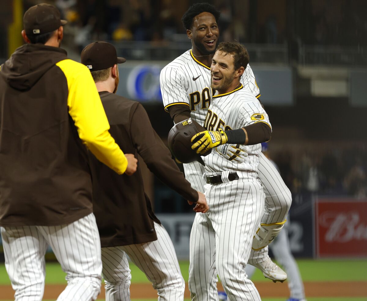 Padres catcher Austin Nola (right) celebrates the winning sacrifice fly with Jurickson Profar in 10th inning Saturday night.
