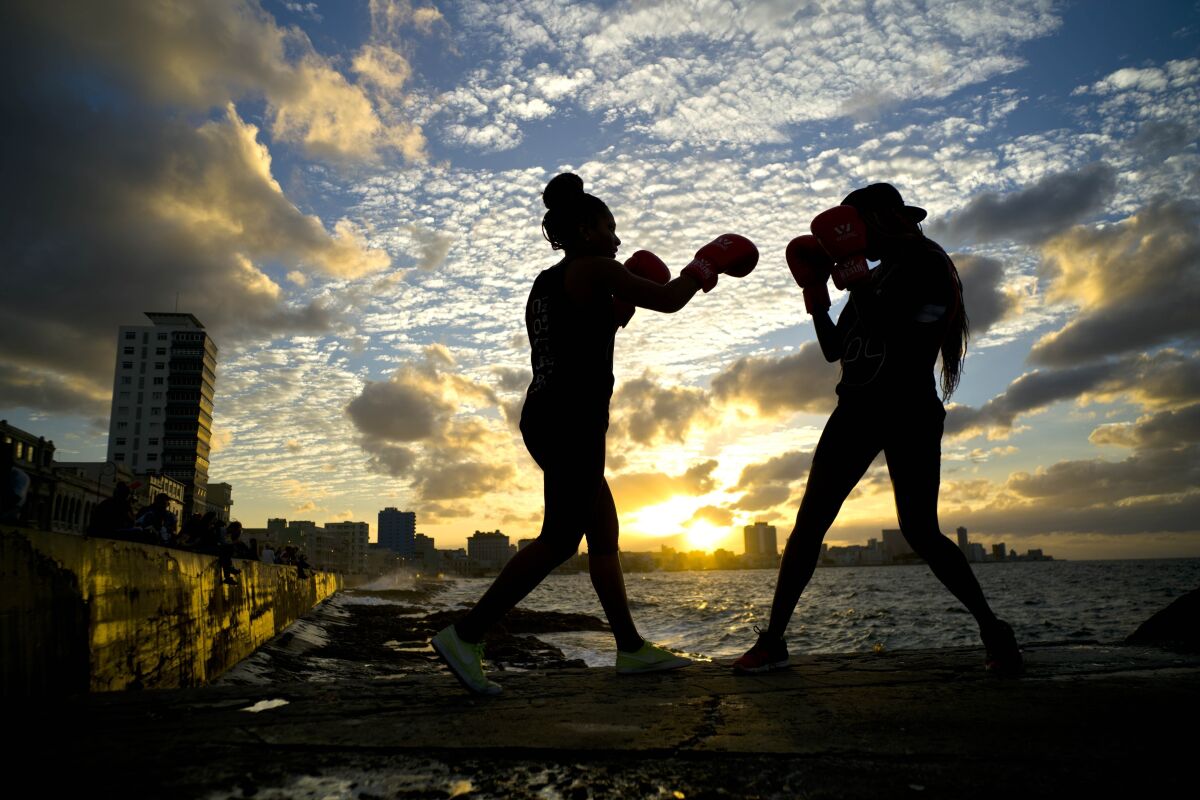 FILE - Boxers Idamerys Moreno, left, and Legnis Cala train during a photo session on Havana's sea wall in Cuba, Jan. 30, 2017. Cuban boxers will be allowed to fight professionally for the first time since the 1960s under a deal with a Mexican promoter, officials announced March 4, 2022. (AP Photo/Ramon Espinosa, File)