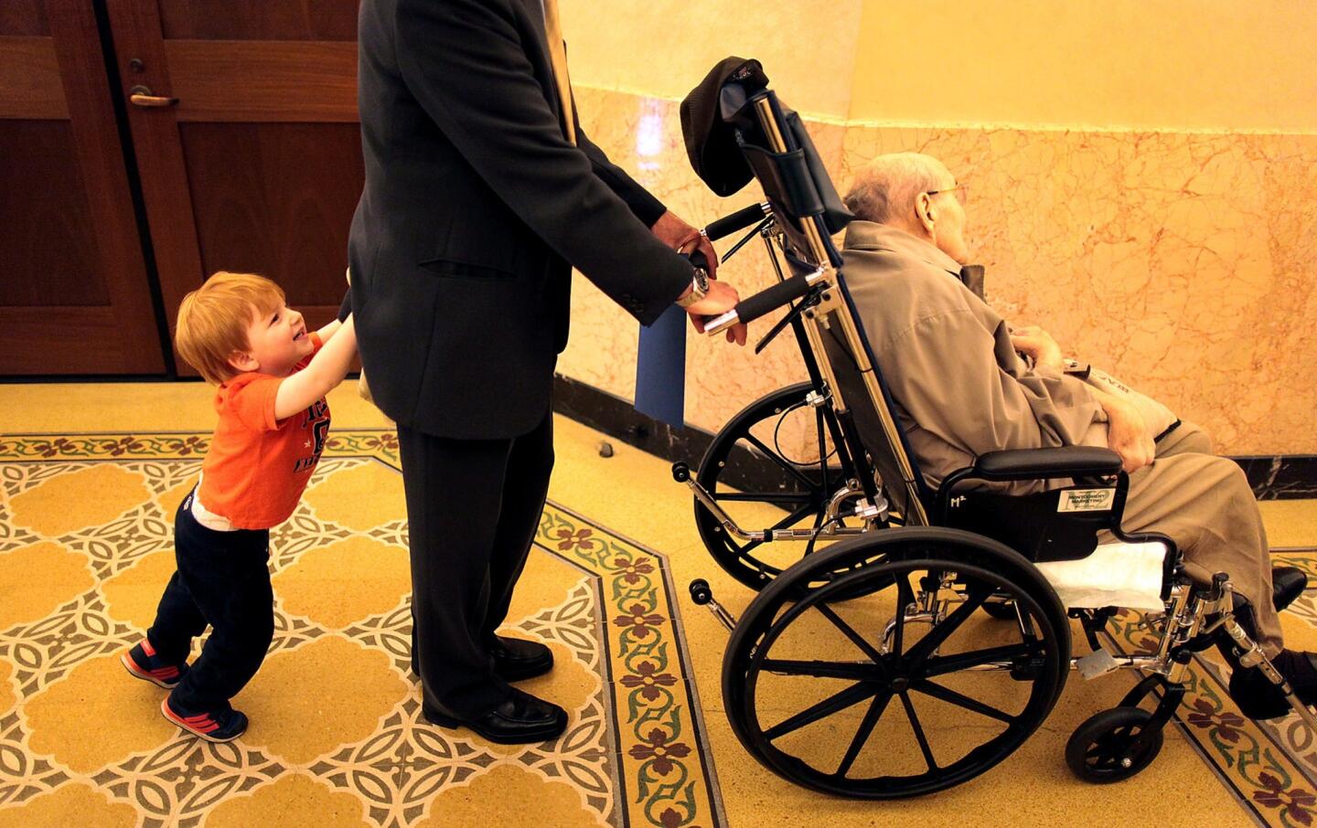 Brent Freedman, 3, pushes his grandfather, Gary Freedman, who is pushing his 100-year-old father, Walter Freedman, after Beverly Hills' tribute to residents who are at the century mark. The city itself turns 100 next week.