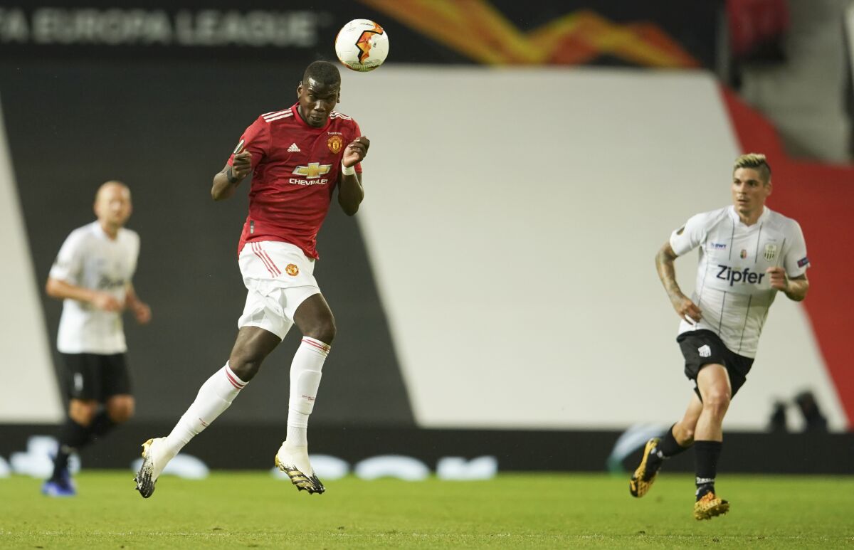 Manchester United's Paul Pogba heads the ball during the Europa League round of 16 second leg soccer match between Manchester United and LASK at Old Trafford in Manchester, England, Wednesday, Aug. 5, 2020. (AP Photo/Dave Thompson)