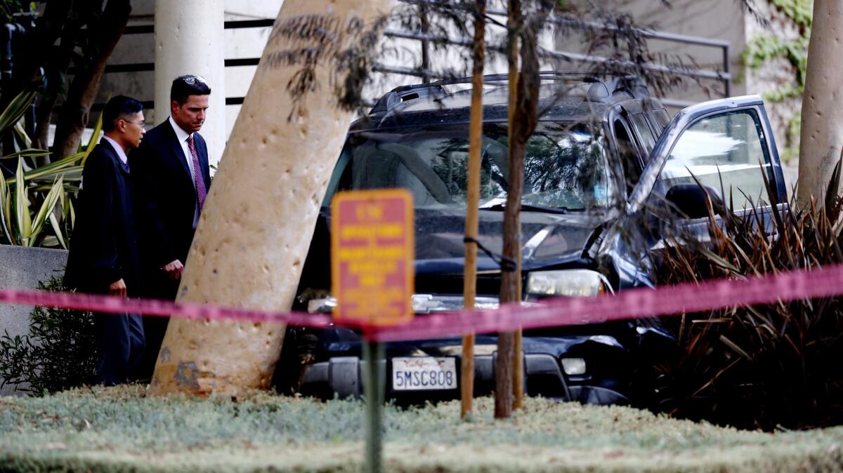 Investigators examine the scene outside Los Angeles County-USC Medical Center in Boyle Heights, where a man was shot and wounded by Los Angeles police.