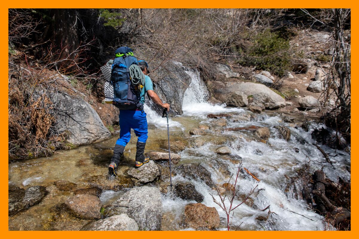 A mountain guide crosses the swollen North Fork of Lone Pine Creek toward the ascent of Mt. Whitney.