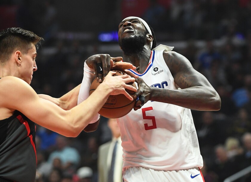 The Clippers' Montrezl Harrell is forced into a jump ball by Portland's Zach Collins while driving to the basket in the second quarter at Staples Center on Monday.