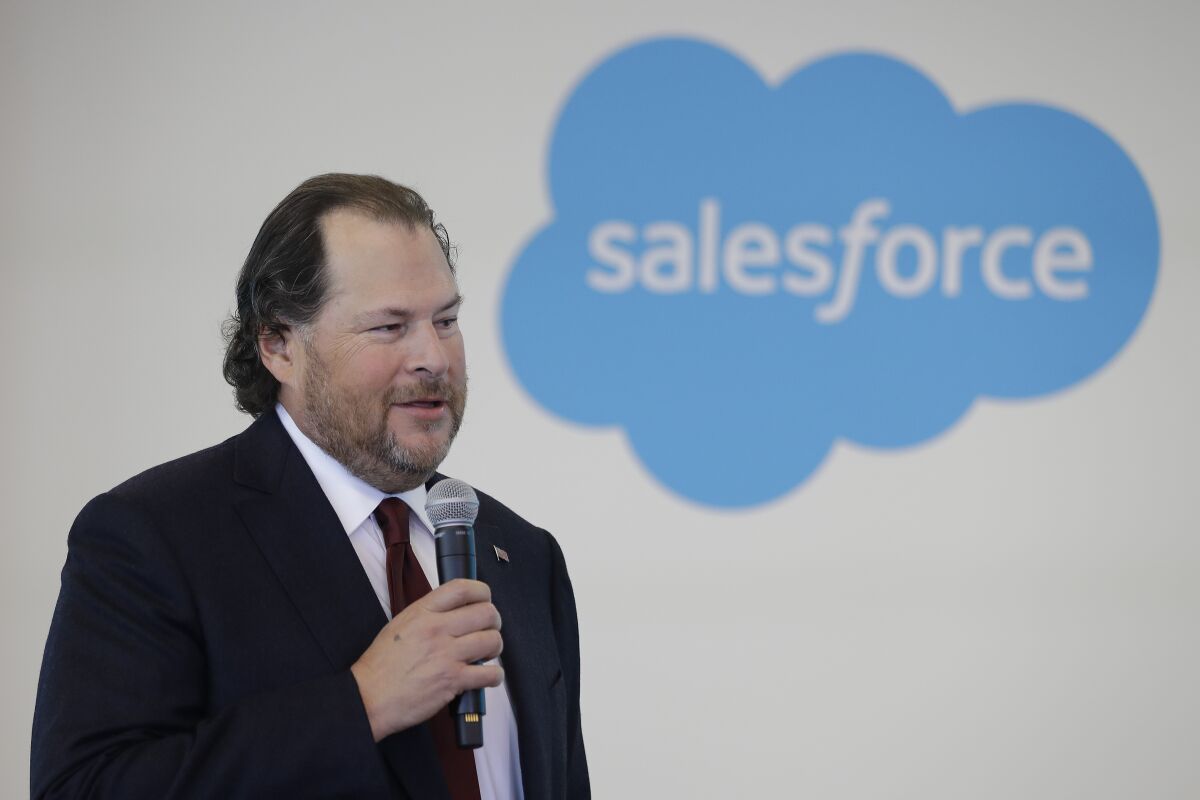 Salesforce Chairman Marc Benioff speaks in front of a company logo