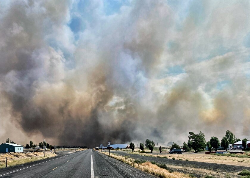 RETRANSMISSION TO CORRECT STATE - This photo provided by the Washington State Department of Transportation shows smoke from a wildfire burning south of Lind, Wash. on Thursday, Aug. 4, 2022. Sheriff's officials are telling residents in the town of Lind in eastern Washington to evacuate because of a growing wildfire south of town that was burning homes. (Washington State Department of Transportation via AP)