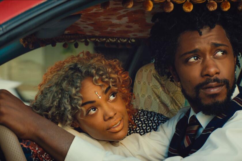 This image released by Annapurna Pictures shows Tessa Thompson, left, and Lakeith Stanfield in a scene from the film, "Sorry To Bother You." (Annapurna Pictures via AP)