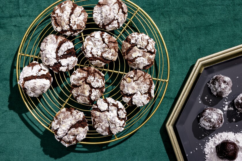 A wiry plate of chocolate cookies dusted with powdered sugar