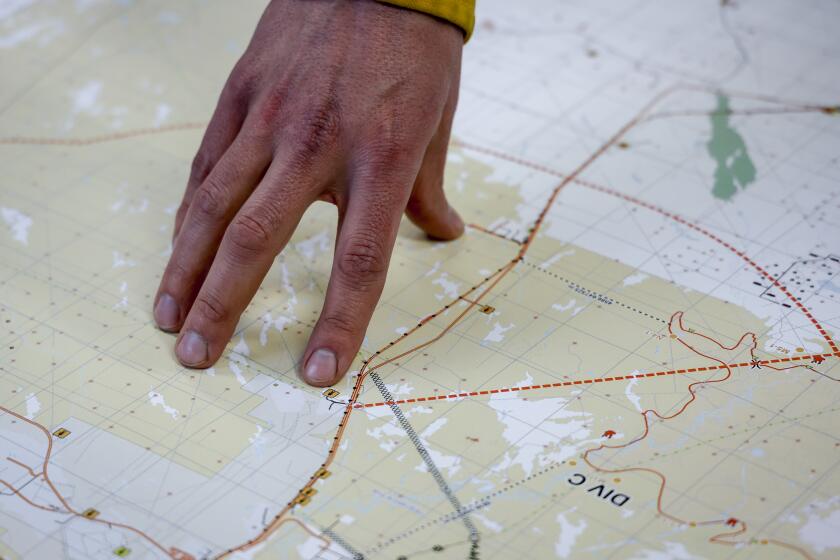 Alberta Wildfire incident commander Gavin Hojka gestures to a map of a wildfire in the incident command post in Fort McMurray, Alta., Thursday, May 16, 2024. (Jeff McIntosh/The Canadian Press via AP)