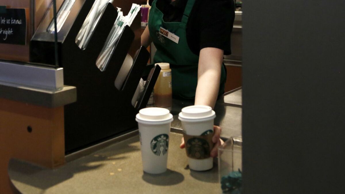 A Starbucks barista moves drinks.