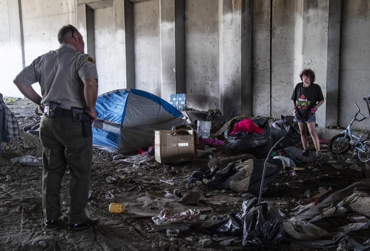 L.A. County Sheriff's Lt. Geff Deedrick talks to a homeless woman who lives near the Whittier Nature Center