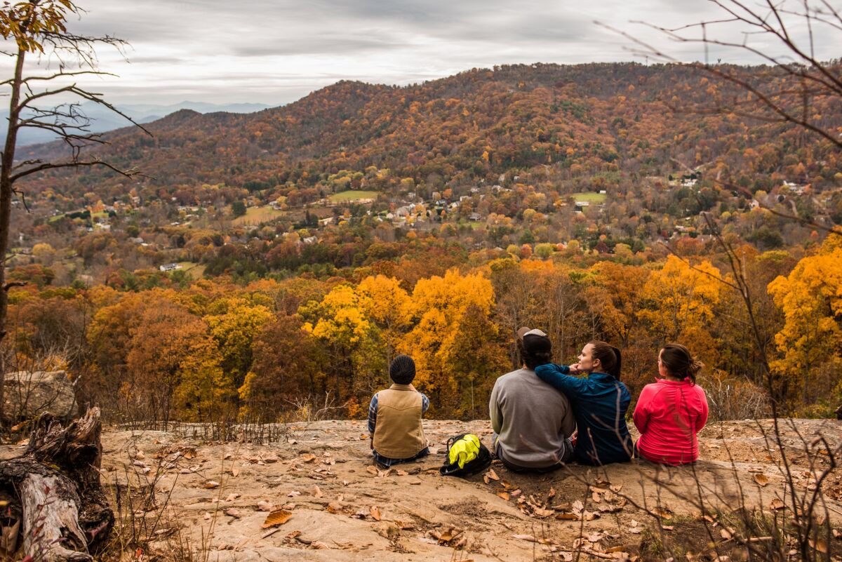 Laura Connor, center right, takes in the view of the Haw Creek Valley with her family along the Blue Ridge Parkway near Asheville, N.C.