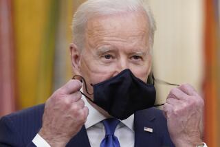 President Joe Biden takes his face mask off before speaking during an event to mark International Women's Day, Monday, March 8, 2021, in the East Room of the White House in Washington. (AP Photo/Patrick Semansky)