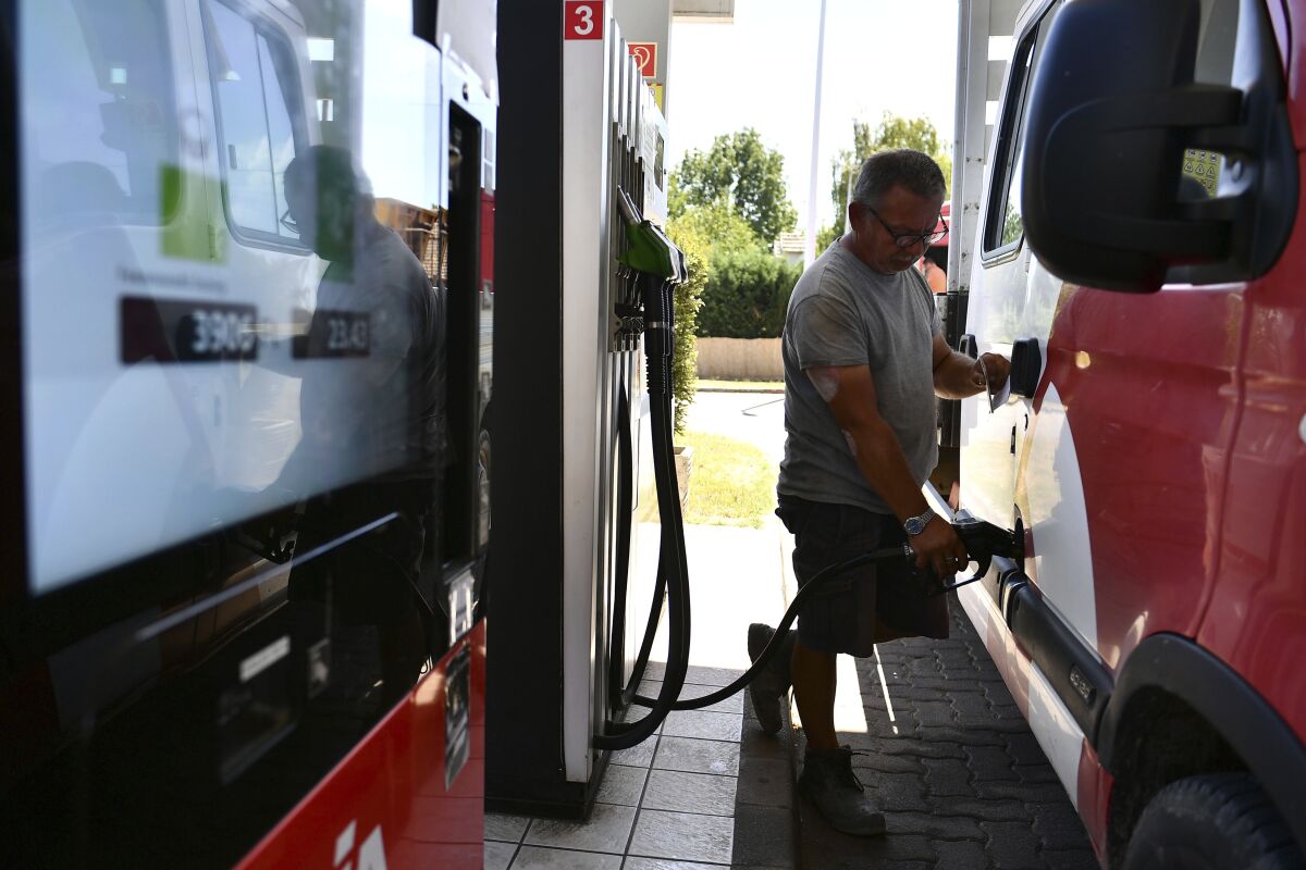 A Hungarian motorist fills up his car in fear of running out of petrol in Budapest, Hungary, Wednesday, Aug. 10, 2022. Oil shipments from Russia through a critical pipeline to several European countries stopped a few days ago, but MOL, the Hungarian petrol company, has paid the transit fee to the Ukrainians instead of the Russians, so the delivery of oil to Hungary via the southern branch of the Friendship pipeline could resume within days according to MOL. (AP Photo/Anna Szilagyi)
