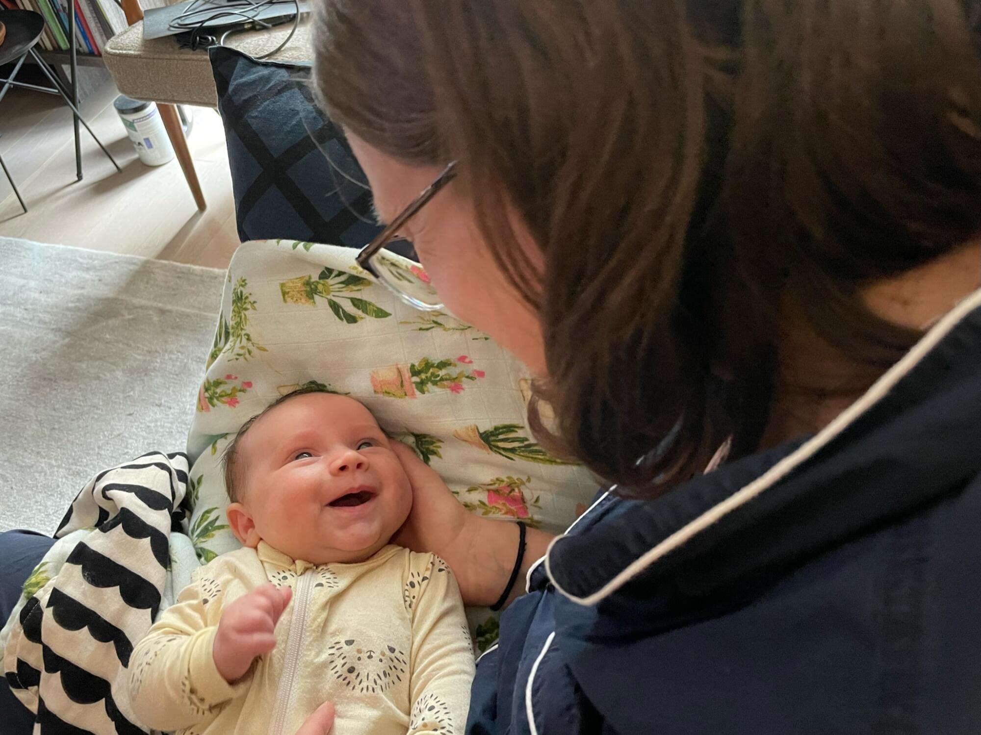 A woman holds her smiling baby.