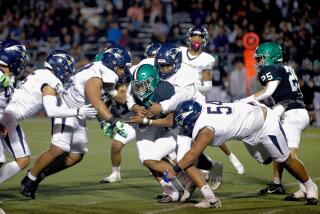 Granada Hills running back Darrell Stanley is tackled in the backfield in a West Valley League opener against Birmingham.
