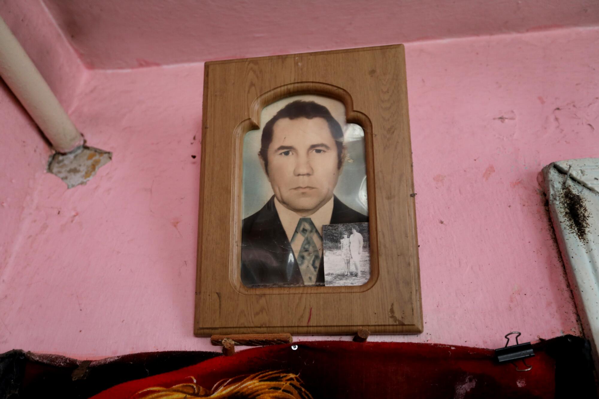 A picture of Anatolii Oliinyk, 90, hangs above the bed where he was found by his son.