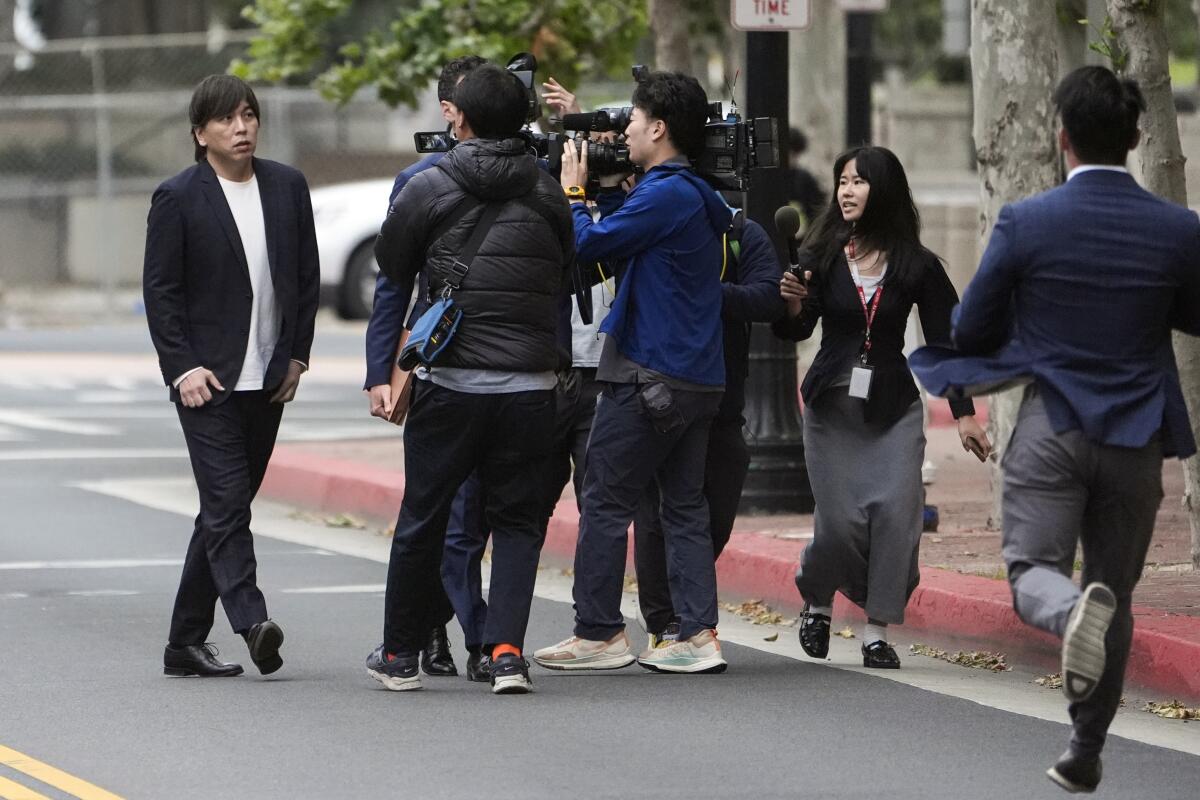 Ippei Mizuhara walks into a courthouse in front of cameras.