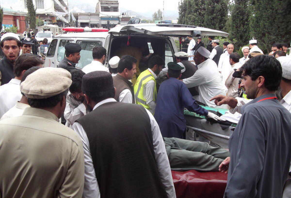 Men help injured blast victims arrive at a hospital following a bombing at an election campaign meeting in the Kurram tribal district in Pakistan on Monday. The bombing killed 25 people and wounded 70 others; bombings Tuesday claimed at least 15 more lives.