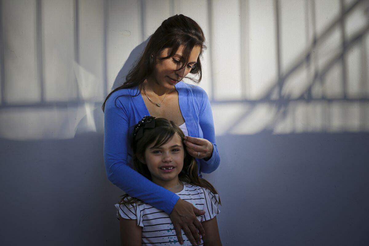 Alysia Padilla-Vaccaro stands with her 8-year-old daughter, Evangelina Vaccaro, who was born with no immune system.