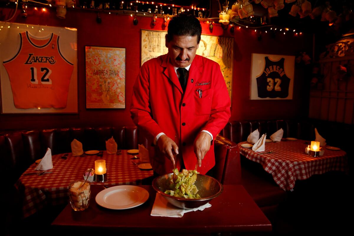 Hector Montenegro, a waiter for 29 years, mixes a Caesar salad at Dan Tana's in West Hollywood.