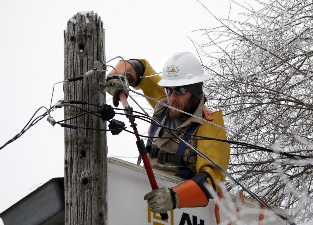 Cory Bean repairs a power line in East Lansing, Mich. Bean, part of a crew from a Kentucky utility service company, has been working in Michigan since Sunday to restore power after an ice storm.