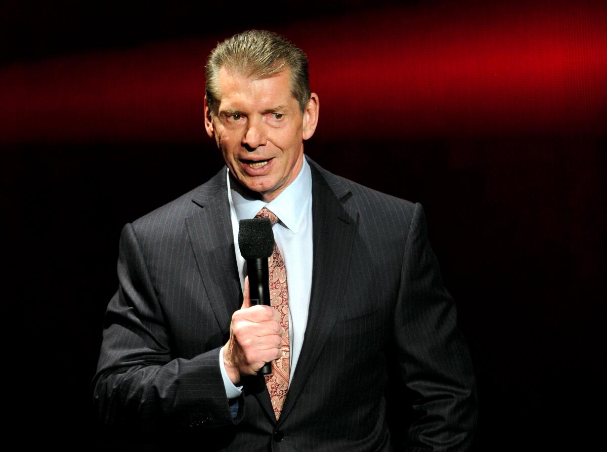 The WWE's Vince McMahon hold a microphone.