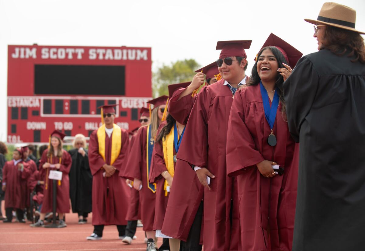 An Estancia High senior laughs before walking during her graduation ceremony at the Jim Scott Stadium.