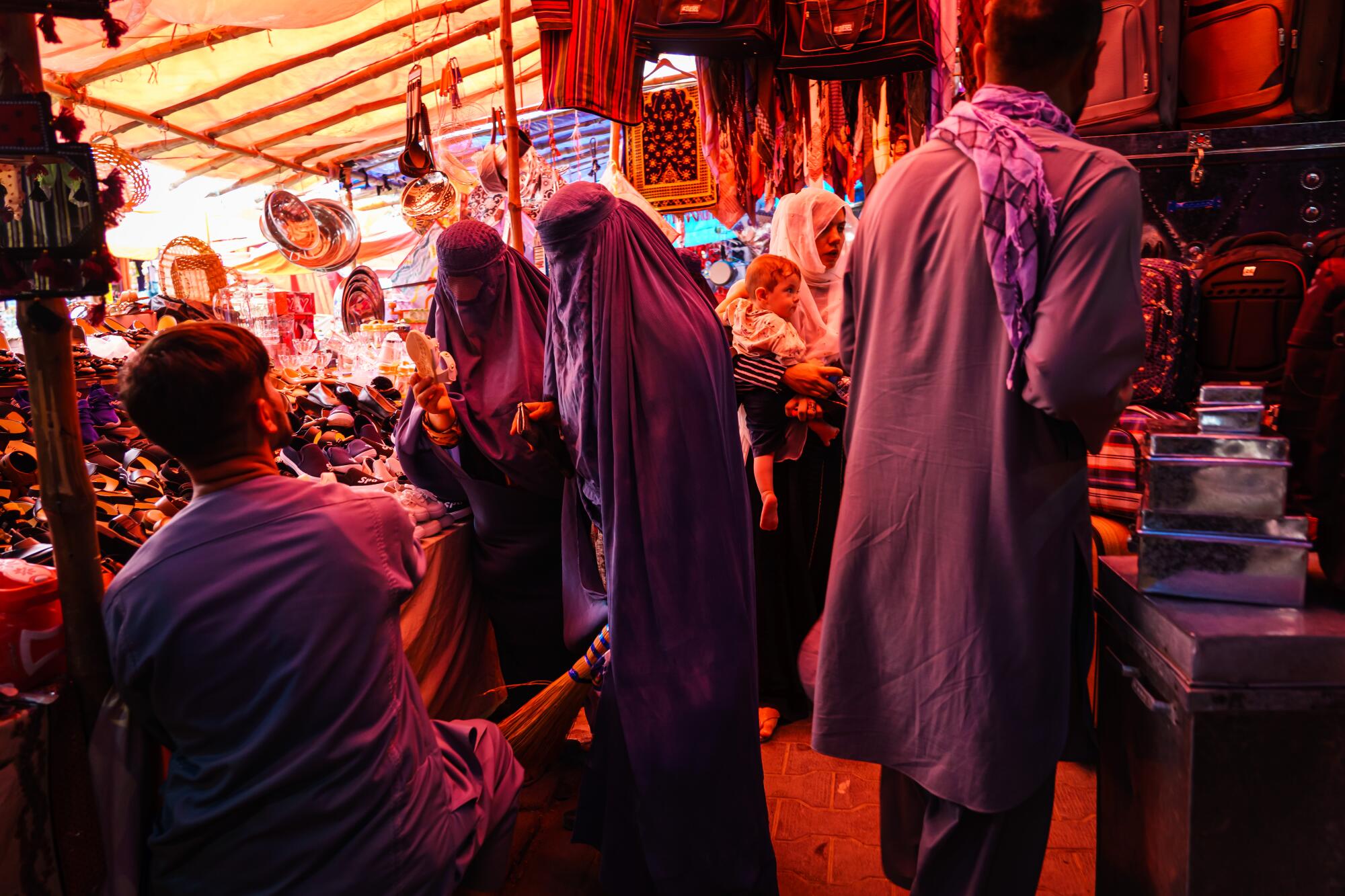 Shoppers in burqas examine merchandise Sunday in the women's area of the Lycee Maryam bazaar in Kabul, Afghanistan. 