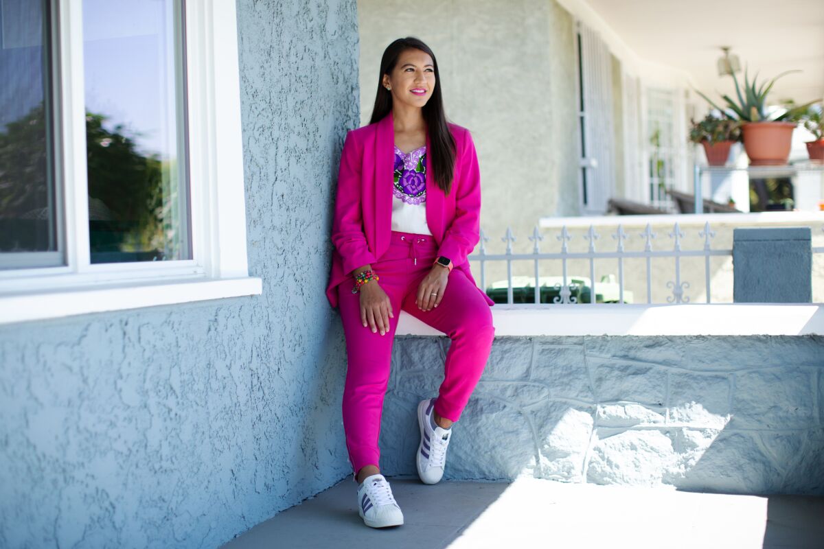 Dulce Vasquez sitting outside in a pink suit