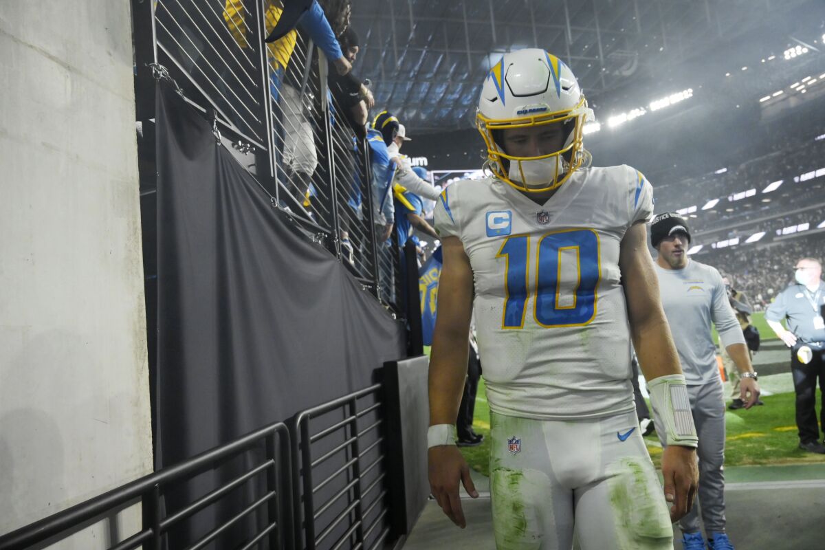 Los Angeles Chargers quarterback Justin Herbert (10) walks off the field after the Los Angeles Chargers lost to the Las Vegas Raiders in overtime of an NFL football game, Sunday, Jan. 9, 2022, in Las Vegas. (AP Photo/David Becker)