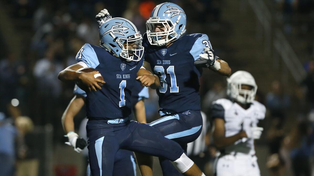 Corona del Mar's Nathaniel Espinoza, left, celebrates with teammate J.T. Murphy after scoring a touchdown in the first half against JSerra in the season opener on Aug. 25, 2017.