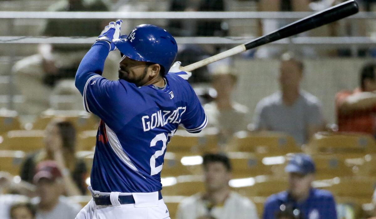 Dodgers first baseman Adrian Gonzalez hits a two-run double against the Giants in the first inning of a spring training game Friday night in Glendale, Ariz.