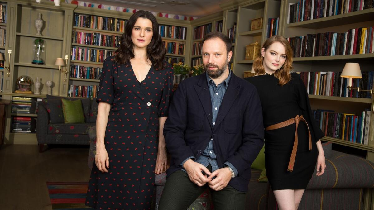 Actresses Rachel Weisz, left, and Emma Stone, right, pose with "The Favourite" director Yorgos Lanthimos, center, at the Whitby Hotel on November 13, 2018 in New York City.