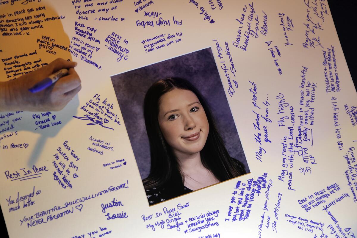 Students sign a card in memory of Gracie Anne Muehlberger, one of two students killed in the shooting this month at Saugus High School in Santa Clarita.
