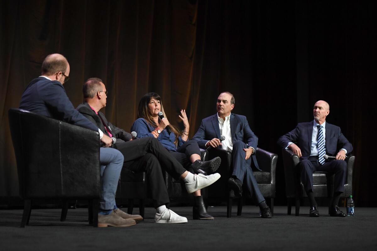 Five people onstage for a panel discussion at CinemaCon.