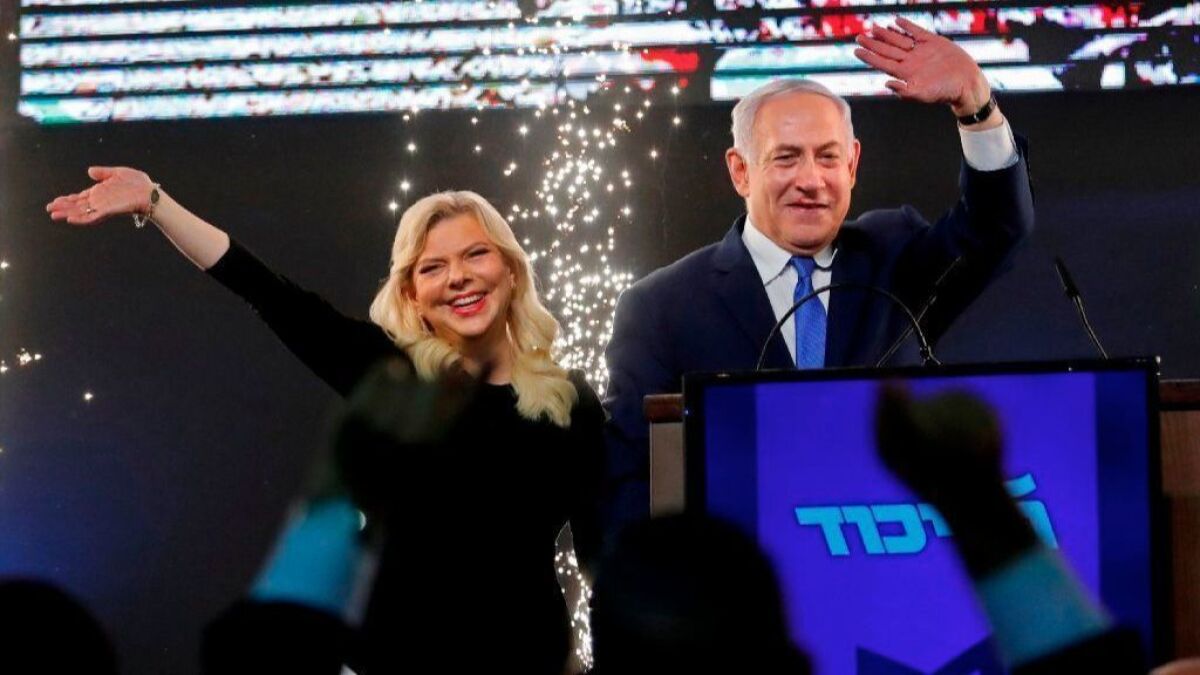 Israeli Prime Minister Benjamin Netanyahu, accompanied by his wife Sara, greets supporters at the Likud Party headquarters in Tel Aviv on election night early on April 10.