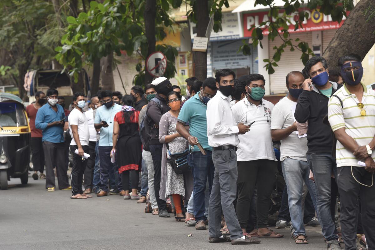 People wait in line for the antiviral drug Remdesivir in Pune, India.