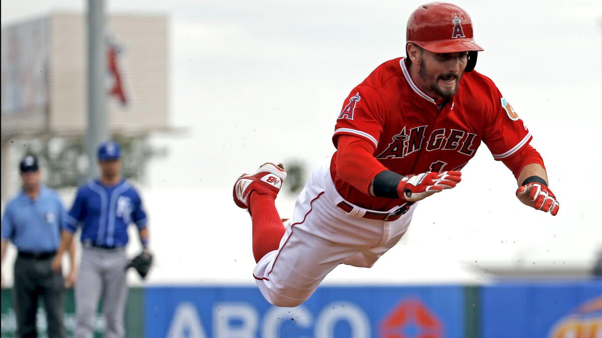 Angels second baseman Johnny Giavotella makes a head-first dive for a triple during the second inning of a spring training game against the Royals on Sunday.