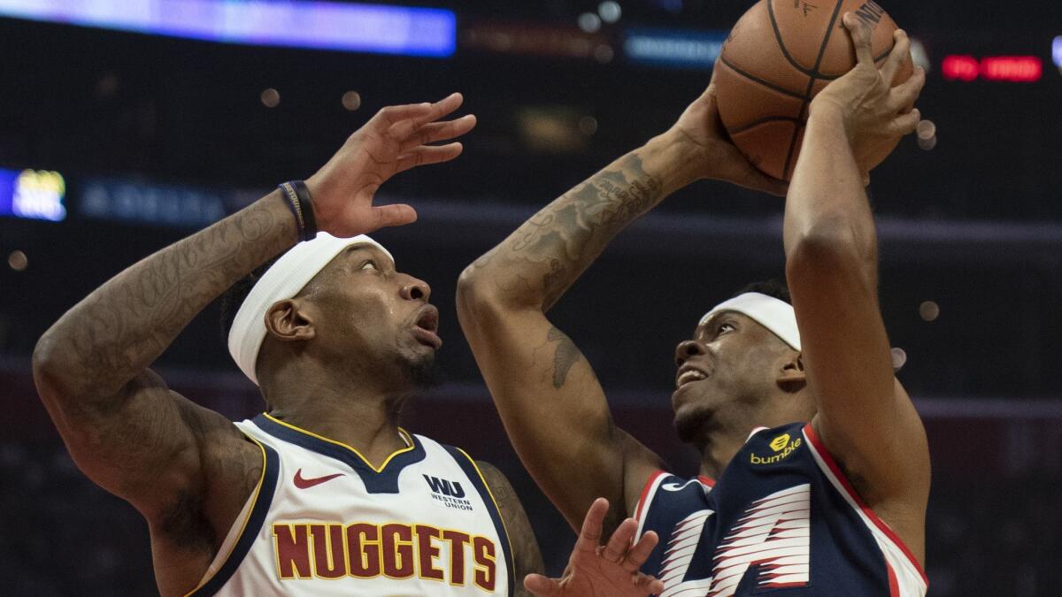 Clippers guard Tyrone Wallace drives to the basket against Nuggets forward Torrey Craig during the first half Saturday.