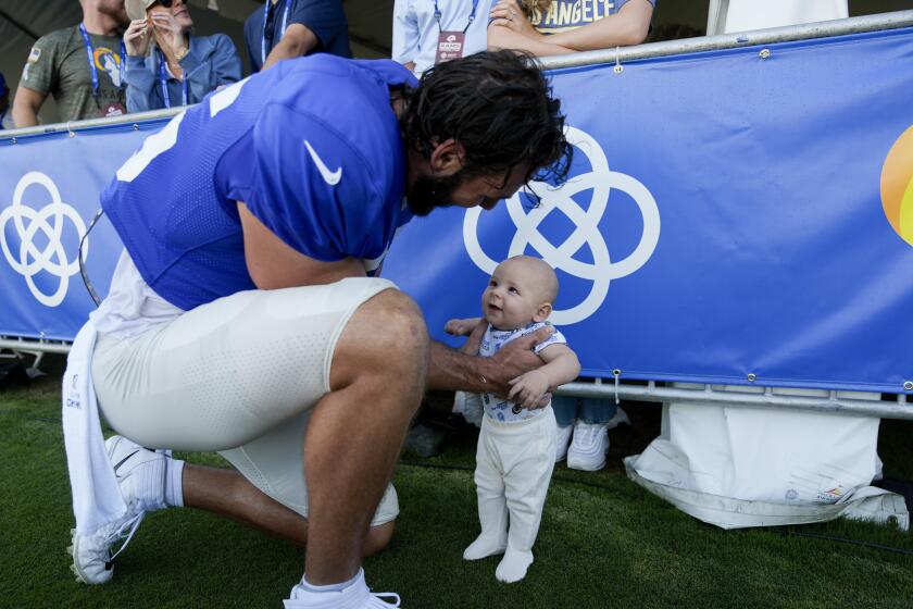 Rams tight end Colby Parkinson holds his son, Forrest, at training camp.